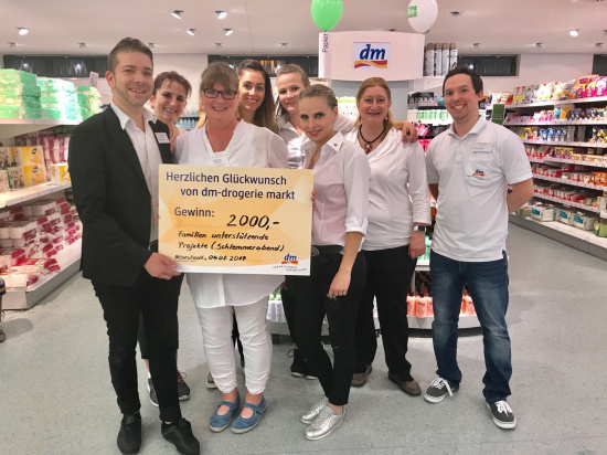 Mitarbeitende des dm-drogeriemarktes mit Koordinatorin Janet Breier bei der Scheckübergabe 2017
