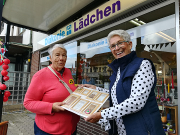 Elke Smolski nimmt einen Hauptgewinn von Elke Koch aus dem Team DiakonieLädchen entgegen