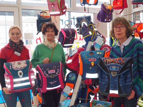 Kerstin Klein, Anke Struck und Andrea Schink (von links nach rechts) laden ein, sich einen Schulranzen schenken zu lassen.