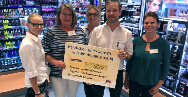 dm-Filialleier Dennis Koskosa überreicht Scheck an Janet Breier für den Förderkreis der Familien unterstürtenden Projekte